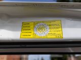 a yellow sticker on the back of a white car