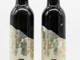 two bottles of wine are sitting next to each other on a white surface