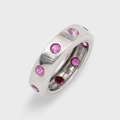 un gros plan d'une bague ornée de pierres roses sur fond blanc