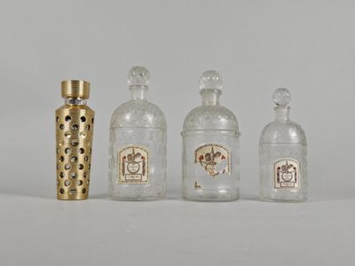 trois bouteilles en verre et un vase doré posés les uns à côté des autres