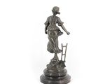 an image of a statue of a woman standing next to a chair