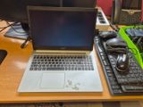 un ordinateur portable posé sur un bureau, à côté d'un clavier