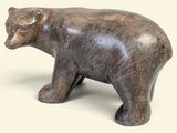 une petite statue représentant un ours sur fond blanc