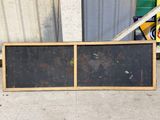 a blackboard on the ground next to a building