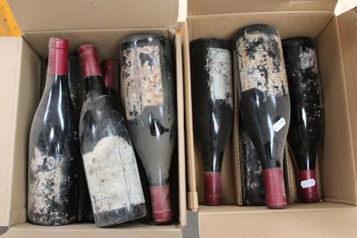several bottles of wine are in a cardboard box on a table