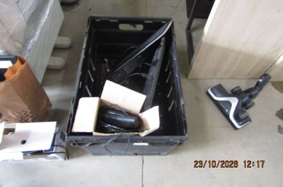 une boîte noire contenant des outils, posée par terre