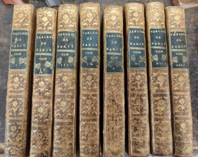 six vieux livres sont alignés sur une table