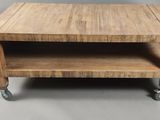 une petite table en bois à roulettes posée à même le sol