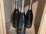 trois bouteilles de champagne posées sur une étagère dans un magasin