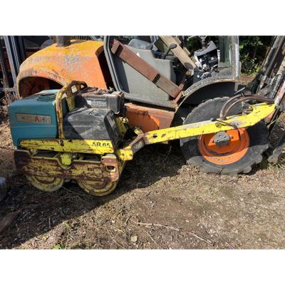 un tracteur qui est à l'arrêt au sol à côté d'un autre tracteur