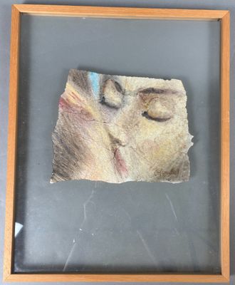 tableau représentant le visage d'une femme, dans un cadre en bois accroché au mur