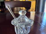 a glass jar with a spoon on a wooden table