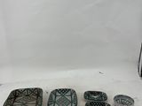 three green and white dishes sitting on top of a white surface