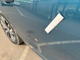 a blue car with a sign on the side of it
