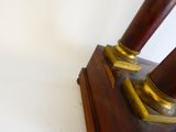 a pair of wooden and brass candles on a stand