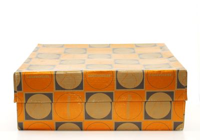 une boîte ornée d'un motif, posée sur une surface blanche