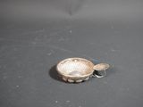 a small silver bowl with a spoon on a table
