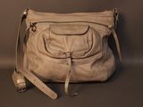 beige leather handbag with shoulder strap on a grey background