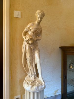 a statue of a woman holding a basket on a pedestal