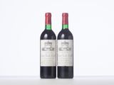 two bottles of red wine sitting on top of a table