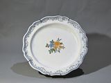 une assiette blanche décorée de fleurs bleues et jaunes