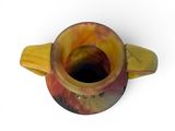 a yellow and red cup with a handle on a white surface