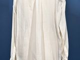 a white shirt on a mannequin stand against a blue background
