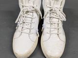 white sneakers with white laces on them on a gray surface