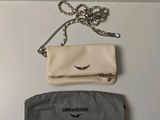a white purse and a black bag on a table