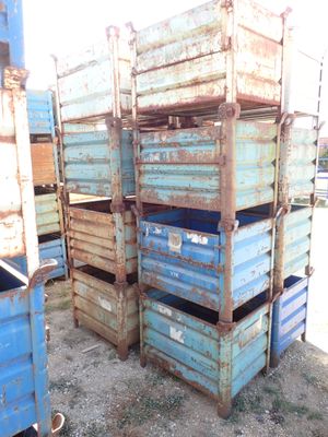 many blue crates stacked on top of each other in the dirt