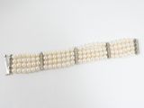 un gros plan d'un bracelet blanc orné de perles, posé sur une surface blanche