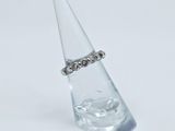 sterling silver ring on clear glass cone on white background