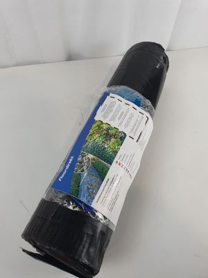 un gros plan sur un rouleau de tissu noir posé sur une surface blanche