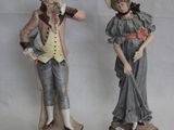 deux figurines d'un homme et d'une femme debout l'un à côté de l'autre
