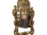 un miroir avec un cadre doré et une image dessus