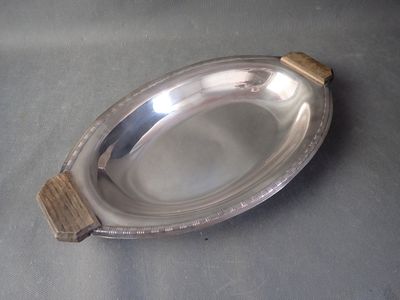 a silver plate with a wooden handle on a table