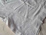 a white blanket on a bed with a white pillow