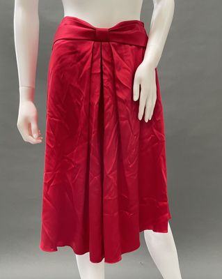 a mannequin wearing a red skirt with a bow around the waist