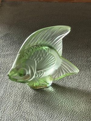 a glass fish figurine sitting on the floor