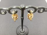 a pair of earrings that are sitting on a stand