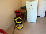 an image of a room with a vacuum cleaner and a refrigerator