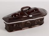 a brown and white ceramic covered dish on a white surface