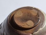 a close up of a brown and white vase on a table