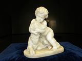 statue d'un garçon sur une planche de surf, posée sur un fond bleu