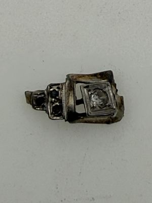 a silver ring with a diamond in it on a white surface