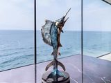sculpture of a marlin marlin fish on a marble table in front of a large window
