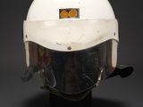 a close up of a helmet on a stand on a black background