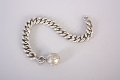 bracelet à chaîne en argent orné d'une boule en argent, sur un fond blanc