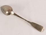 a spoon that is sitting on a white surface
