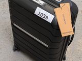 a black suitcase with a tag on it sitting on the ground
